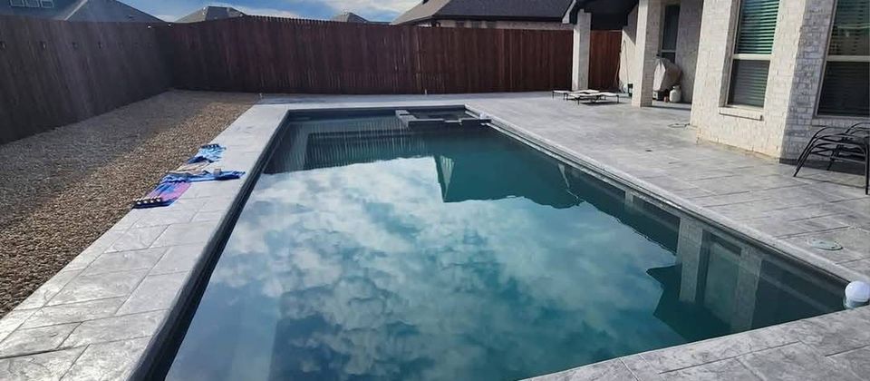 Stamped concrete overlay patio with a stone fireplace